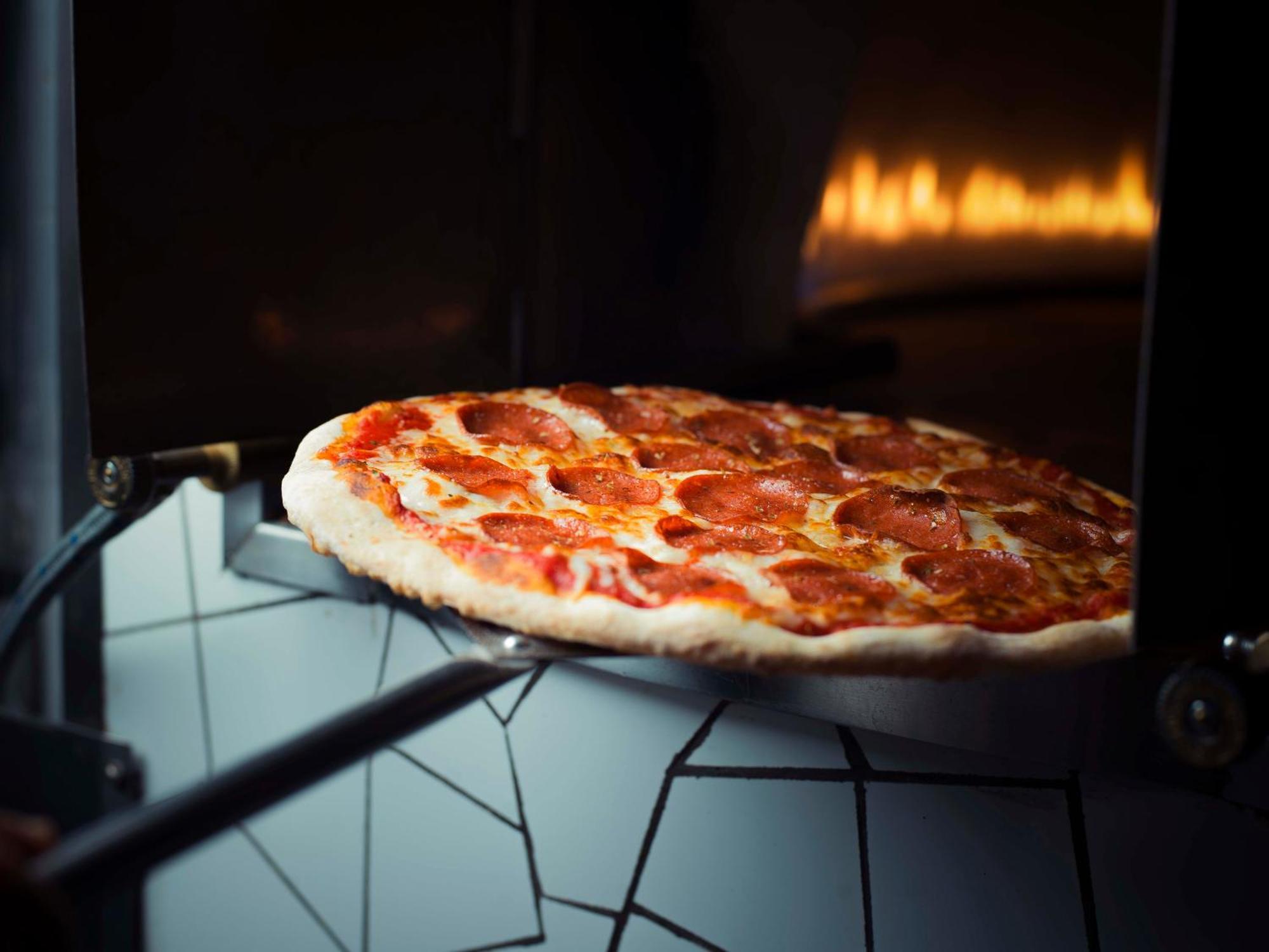 Sheraton Dammam Hotel & Convention Centre Kültér fotó Pizza being removed from a wood-fired oven